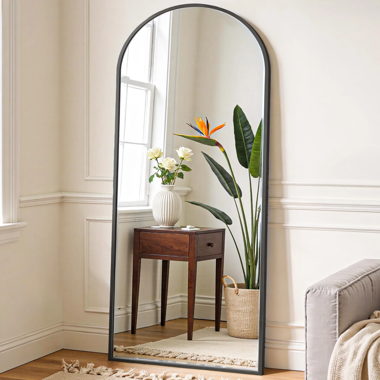The arched floor mirror doing the corner its one job: the whole person in one look.